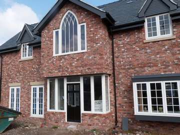 Heswall , Wirral : New Biuld Installtion of Evolution Storm PvcU Windows, also showing an arched Timber frame from G Barnsdales. Front Door by the English door Company 